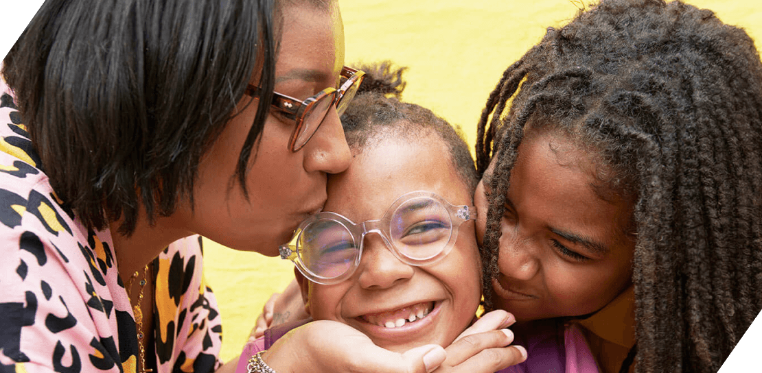 Two young girls and a mother embracing in a hug